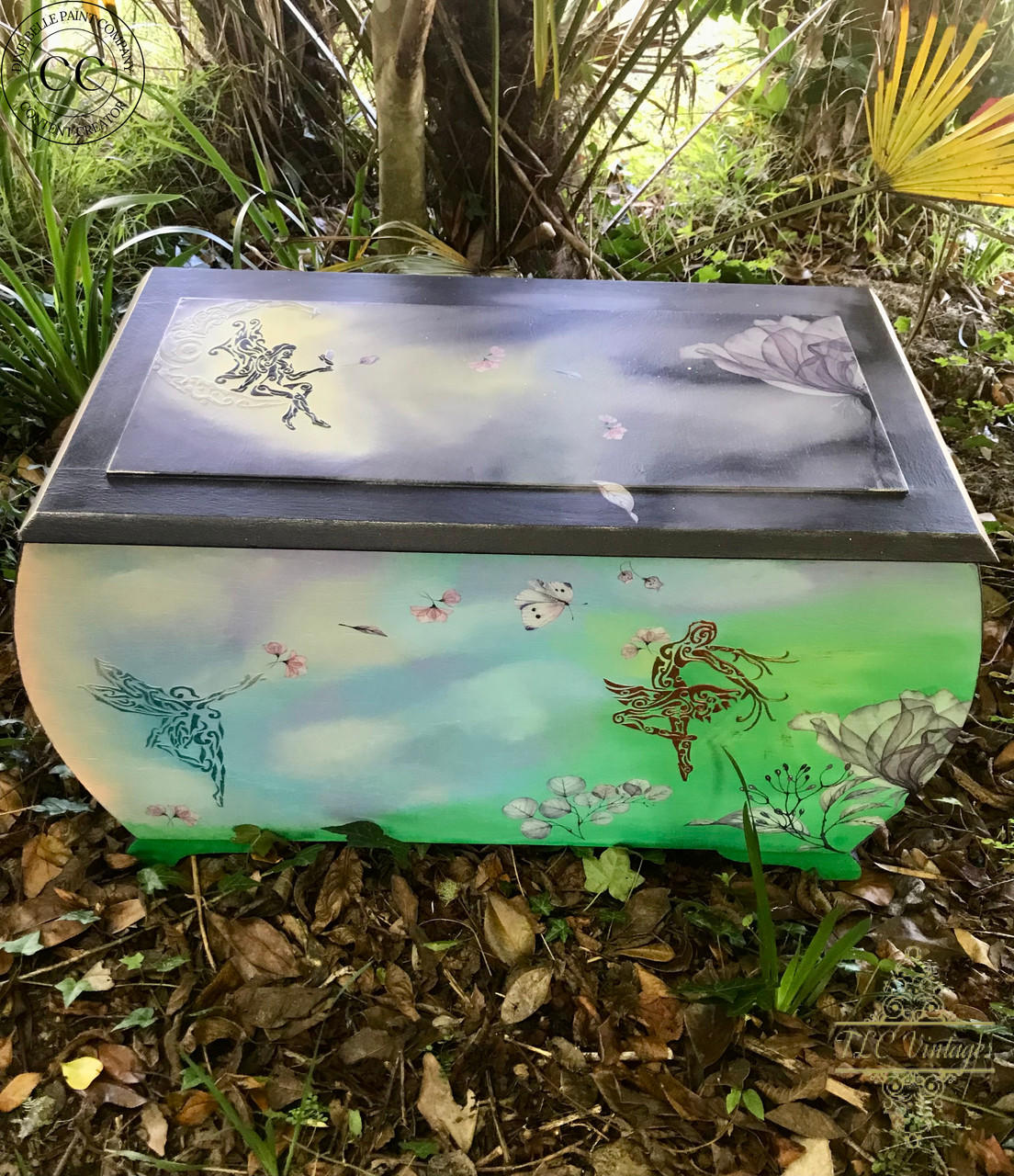 Belles and Whistles Fairies - Stencil provides an extra decorative touch to any project! Painted chest makeover in green, blue, purple and white creating a sky and grass scene. One fairy applied on top of the chest in purple. Two fairies applied on the front of the chest in teal and one in a copperish red. The Translucent Garden rub on furniture transfer was also applied throughout the piece and around the fairies.