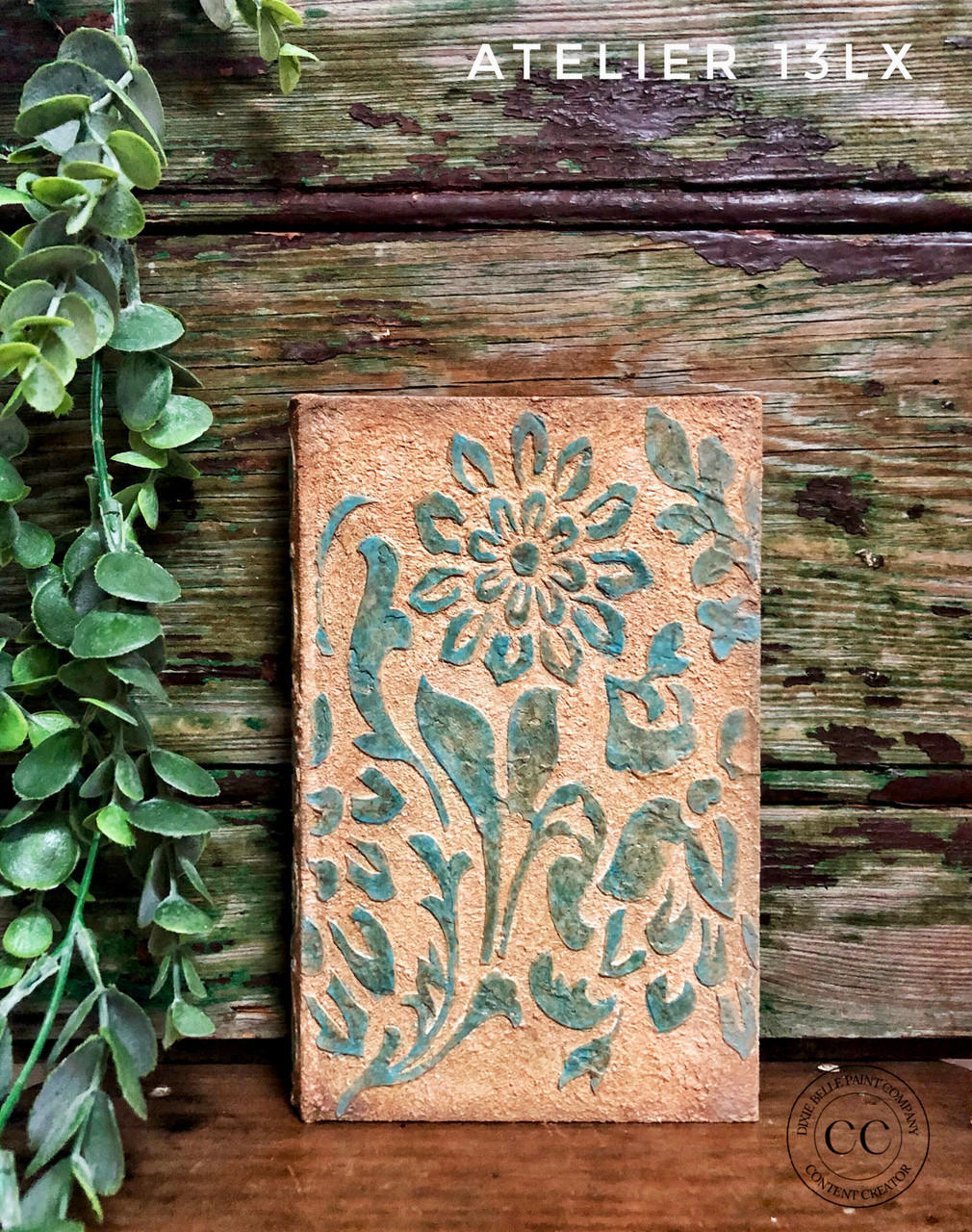 Belles and Whistles Tea Towel Floral - Stencil
Textured copper/rusty canvas using Tea Towel Floral - Stencil and Dixie Mud to give the stencil a raised effect painted in blue. Staged in front of damaged wooden wall with greenery.