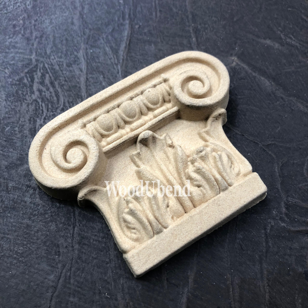 WoodUBend Applique #6079 (Set of 2) is the perfect mouldable embellishment for any project!
One of the Applique #6079 (Set of 2) is seen flat staged on a black crinkled background.