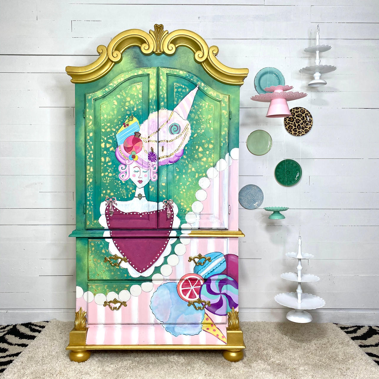 WoodUBend Keyhole #987 is the perfect mouldable embellishment for any project!
A child's wardrobe with a whimsical child candyland painting and design. The wardrobe has Keyhole #987 on the furniture piece. Staged on the walk next to the piece are ceramic plates as well as hanging cupcake and cake stands.