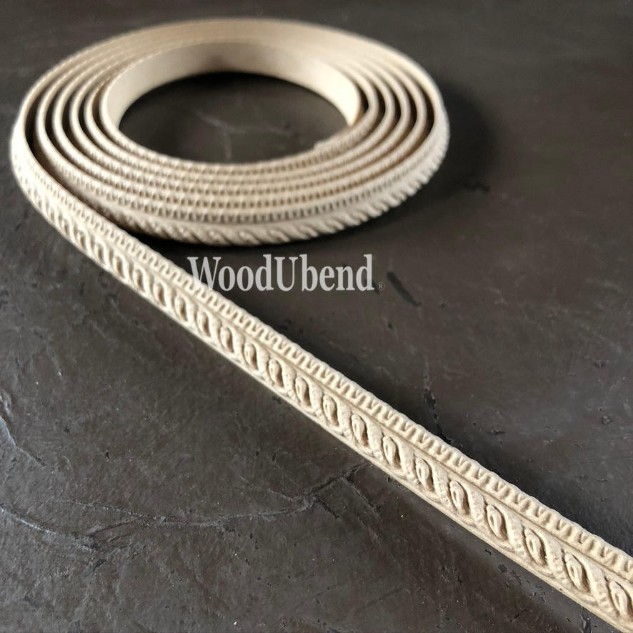 WoodUBend Trim #TR710 (Set of 2). A roll of WoodUbend sitting on top of a black table, unrolling at one end.