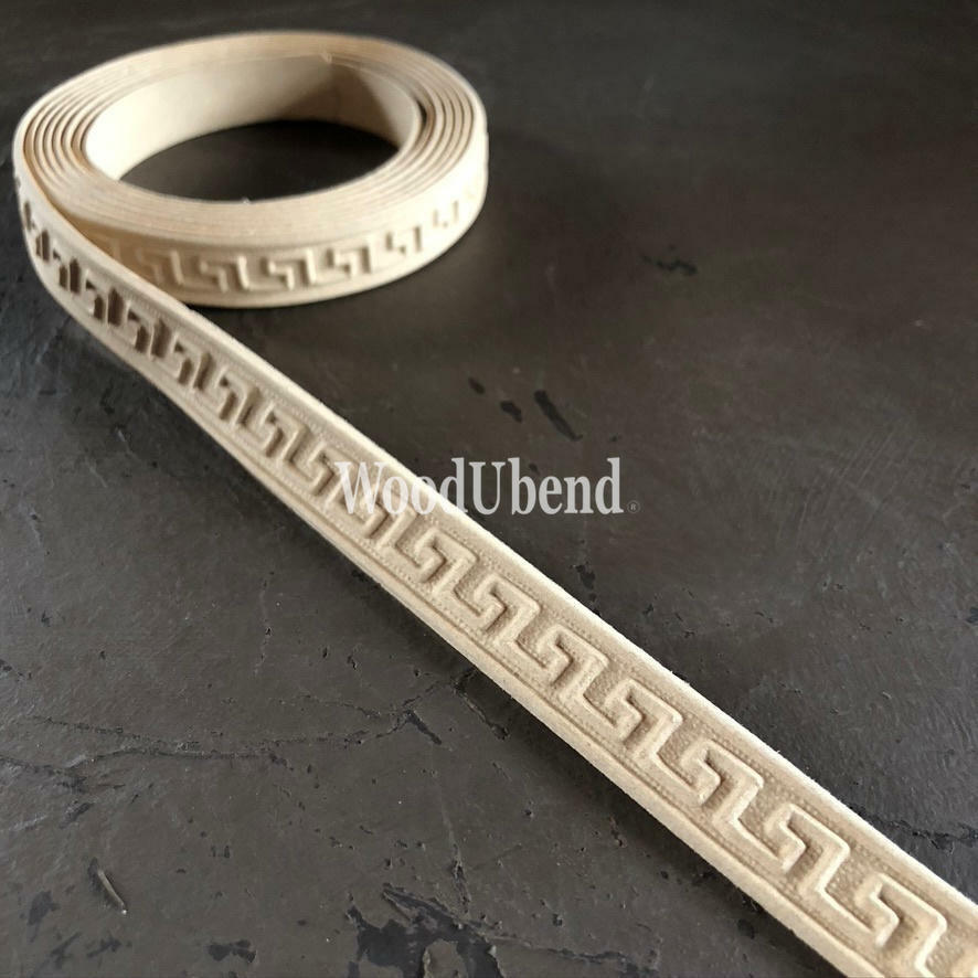 WoodUBend Trim #TR715 (Set of 2) is the perfect mouldable embellishment for any project! A roll of WoodUbend witting on top of a brown table, unrolling at one end.