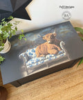 A painted chest features an image of a highland cow lounging on a blue and white floral sofa. A potted plant sits nearby on a woven rug, and a black star wall decoration is visible above.
