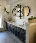 Bathroom with two sinks, marble counter tops, the cabinets have been painted with Silk All In One Mineral Paint.  Two round mirrors and plants are staged throughout.