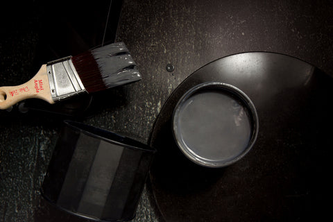 Iron metallic paint can with a brush on a dark surface