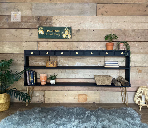 plant stand painted with black all in one paint staged with plants and vases in front there is a rug and a plant to the left