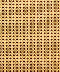 Close-up of a woven cane chair seat with a hexagonal pattern. The natural beige material forms a symmetrical, openwork design, creating a textured and airy appearance.