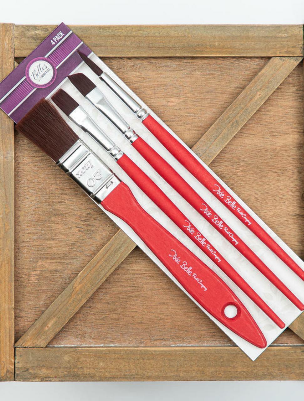 Belles and Whistles Artist Brushes. Artist brushes in packaging on top of wooden box.