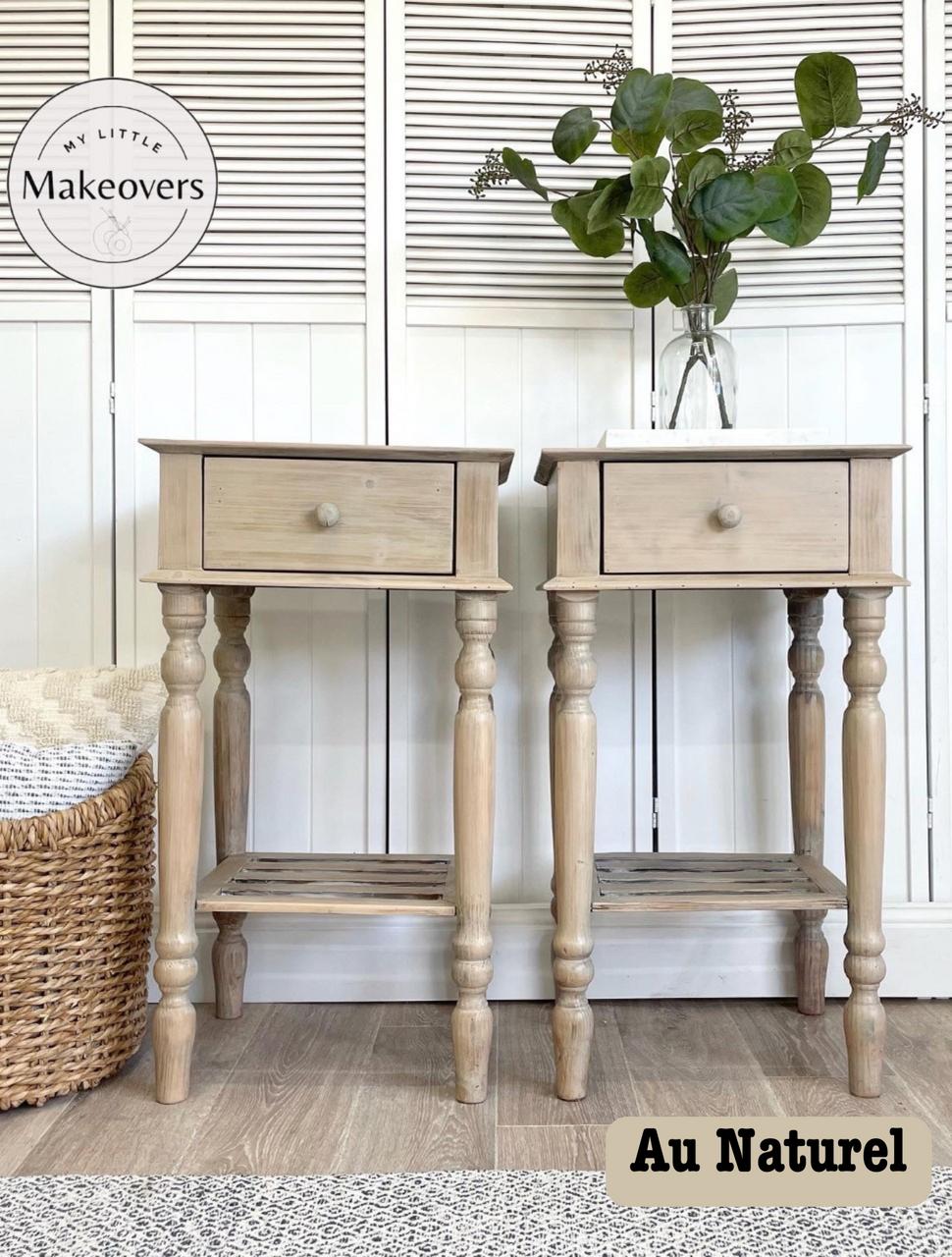Two light wood nightstands with single drawers, styled with green potted plants on top. The background features a wicker basket and a white shuttered cabinet. A logo reads "My Little Makeovers" and the text "Au Naturel" is in the bottom right corner.