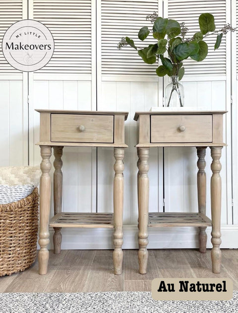 Two light wood nightstands with single drawers, styled with green potted plants on top. The background features a wicker basket and a white shuttered cabinet. A logo reads "My Little Makeovers" and the text "Au Naturel" is in the bottom right corner.