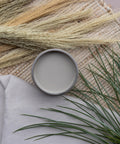 Overhead shot of an open jar of Badlands staged on a burlap table runner with faux greenery and a drop cloth.
