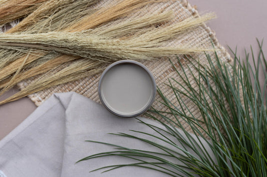 Overhead shot of an open jar of Badlands staged on a burlap table runner with faux greenery and a drop cloth.