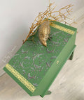 Green painted chest with a gold keyhole on the front. The Baroque Swirls Transfer has been applied on the top with the gold borders on each side. Staged with gold sticks and a gold bird statue on top.