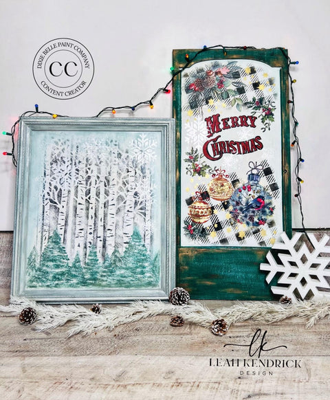 Belles and Whistles Buffalo Check - Stencil provides an extra decorative touch to any project!
Picture frame with Birchwood - Stencil inside with pine trees painted In front. Staged next to green board with "MERRY CHRISTMAS " with Holiday Joy - Stencil around the words painted on. Christmas lights hang around both piece and pinecones lay in front of pieces.