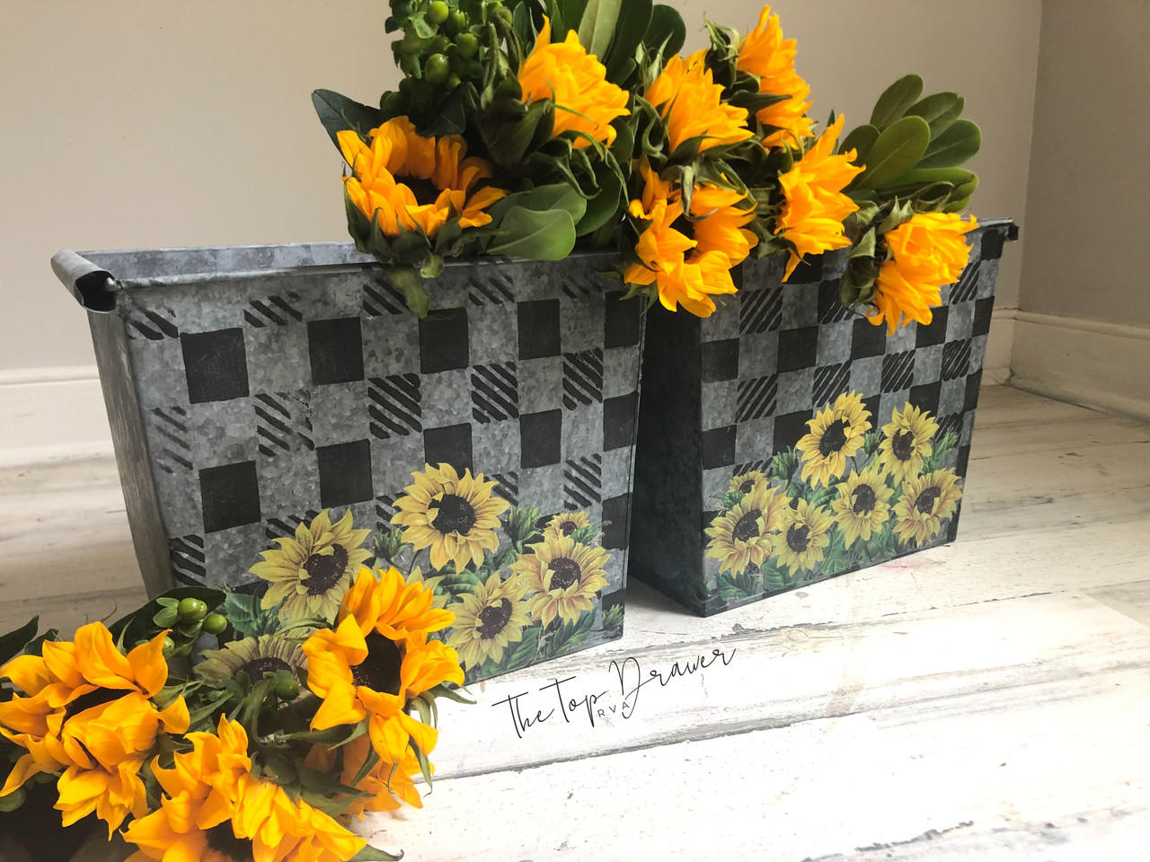 Belles and Whistles Buffalo Check - Stencil provides an extra decorative touch to any project!
Two metal baskets with the Buffalo Check - Stencil  and with the Sunflower - Transfer on the bottom. Staged with Sunflowers inside and around the baskets.