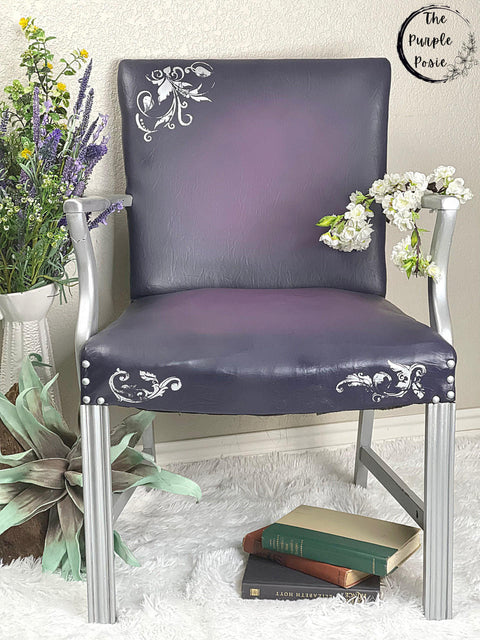 Belles and Whistles Butterflies - Silkscreen Stencil provides an extra decorative touch to any project!
Leather chair using Butterflies - Silkscreen Stencil on the top left corner and on the front trim of the seat. Staged with greenery and flowers around piece as well as a stack of books under the chair.