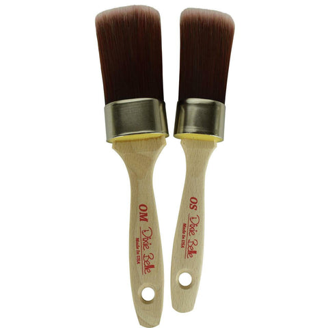 Belles and Whistles DBP Synthetic Brushes. A closeup product image displaying the Oval Medium (OM) and Oval Small (OS) synthetic brushes on a transparent background.