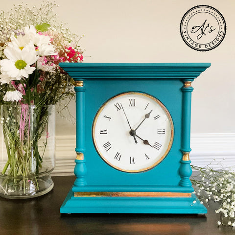 Belles and Whistles Dixie Shine 
Antique wooden clock painted a bright blue with Dixie shine in gold around the woodwork.