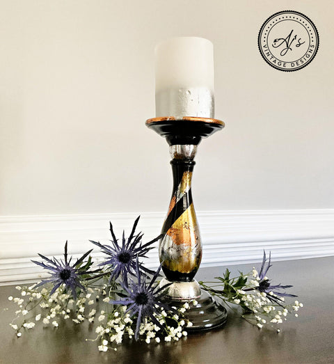 Belles and Whistles Dixie Shine 
Candle holder with a silver metal base using all 3 Dixie shine color around base with a black swirl from top to bottom of piece. Staged with a white with silver gradient candle and purple and white flowers are the bottom.