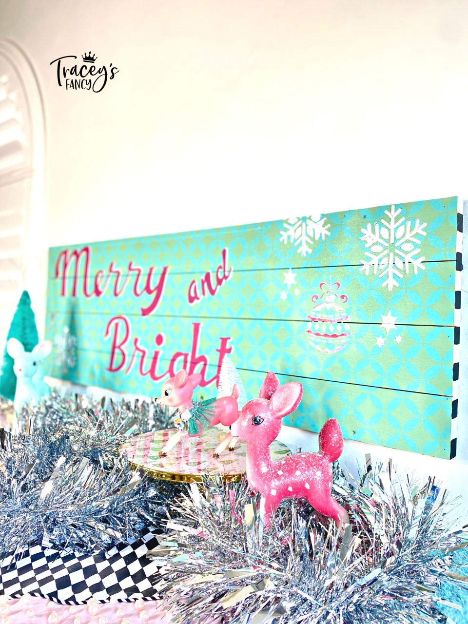 Belles and Whistles Holiday Joy - Stencil provides an extra decorative touch to any project!
A blue Sign with Holiday Joy Stencil "MERRY AND BRIGHT" and Retro Lattice Stencil in the background. Staged in front of the sign is silver tinsels and figurines of rednosed reindeer.