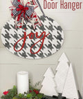 Belles and Whistles Houndstooth - Stencil provides an extra decorative touch to any project!
A white sign with Houndstooth - Stencil in black with the words "JOY" in red. Staged on the sign is a red and checkered ribbons with a Santa Claus ribbon as well tied together into a bow. Under the piece are two tree stands, along with a white candle and a wreath around candle.