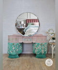 Belles and Whistles Lotus Bloom - Stencil provides an extra decorative touch to any project!
Pink and green vanity with circular mirror. Using Lotus Bloom - Stencil using white paint along the top drawers in a row.