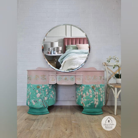 Belles and Whistles Lotus Bloom - Stencil provides an extra decorative touch to any project!
Pink and green vanity with circular mirror. Using Lotus Bloom - Stencil using white paint along the top drawers in a row.