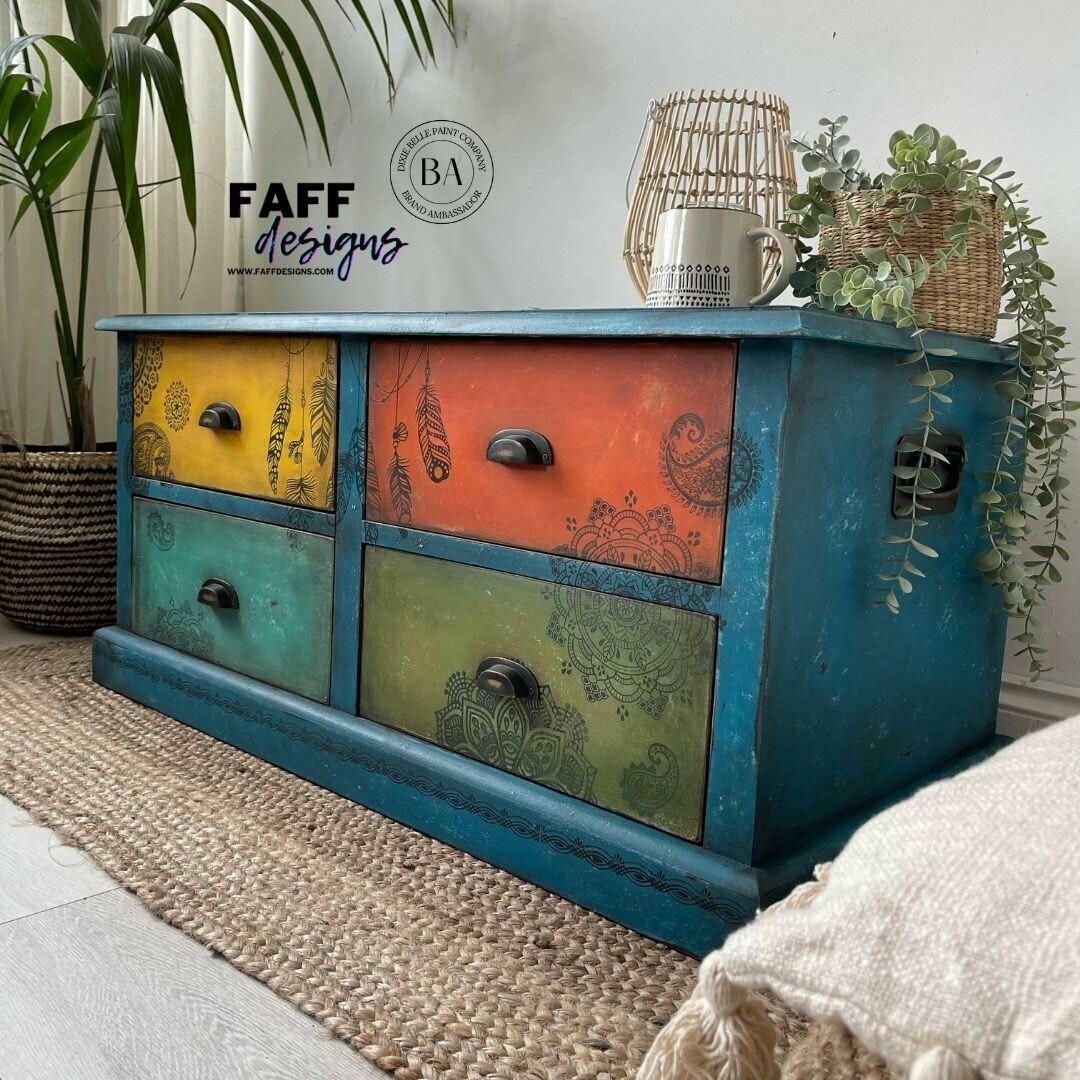 Belles and Whistles Mandala - Silkscreen Stencil provides an extra decorative touch to any project! Colorful Chalk Painted Dresser with painted on Mandala Silkscreen Stencil and feather stencils. Staged with a wicker basket and trailing ivy plants.