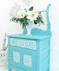 Belles and Whistles Morocco - Stencil provides an extra decorative touch to any project!
Light Blue Chalk painted washstand with white Morocco Stencil painted on the door fronts, with glass knobs. Staged with a white vase and white flowers.