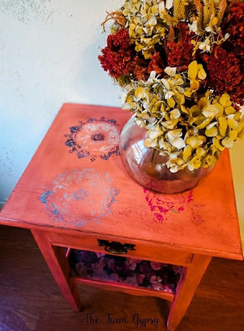 Belles and Whistles Mosaic - Silkscreen Stencil provides an extra decorative touch to any project! Red end table painted with Belles and Whistles Mosaic Silkscreen Stencil on top. Staged with Florals and glass vase.