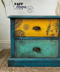 Belles and Whistles Mosaic - Silkscreen Stencil provides an extra decorative touch to any project! Close up of a blue long dresser with a yellow drawer and black hardware. Painted with Belles and Whistles Mosaic Silkscreen Stencil.