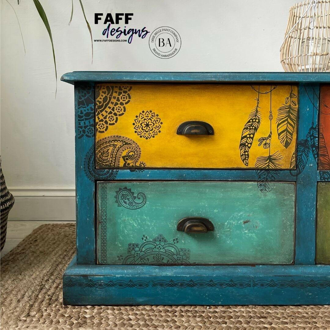 Belles and Whistles Mosaic - Silkscreen Stencil provides an extra decorative touch to any project! Close up of a blue long dresser with a yellow drawer and black hardware. Painted with Belles and Whistles Mosaic Silkscreen Stencil.