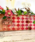Belles and Whistles Roses - Silkscreen Stencil provides an extra decorative touch to any project! A leather case with a red diamond stencil on the front and top with the rose stencil painted lightly in white. The case is staged with flowers on top.