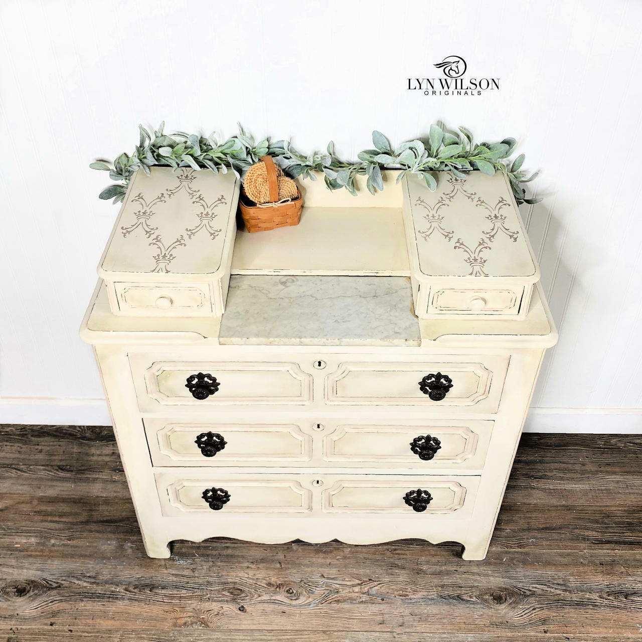 Off white painted dresser with black pulls. The Royal Damask stencil has been applied in brown on the top of the dresser.