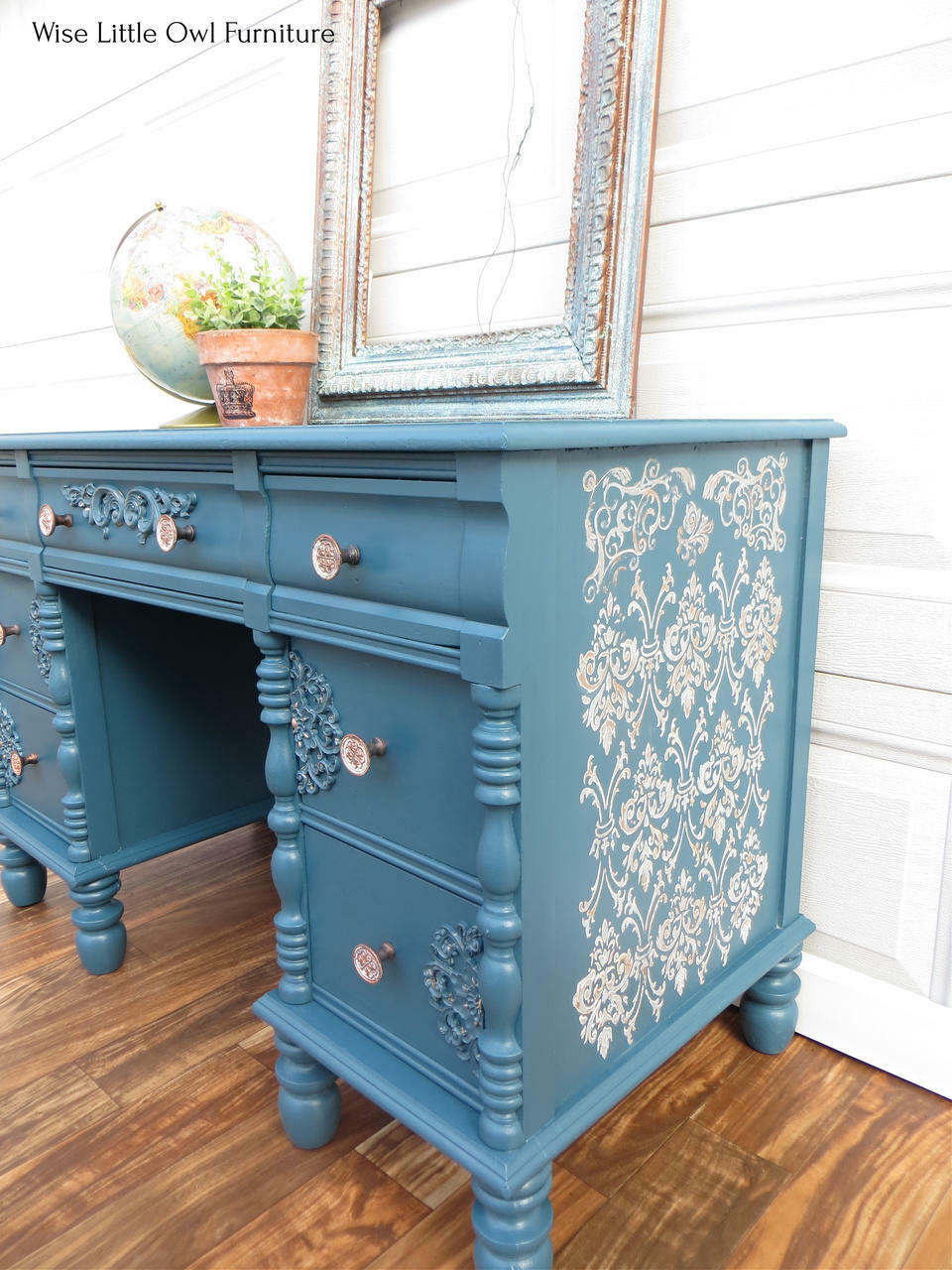 Blue painted desk with wood details on the drawers. Royal Damask stencil has been applied on the side of the desk.