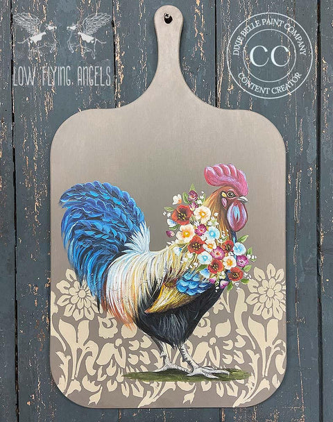 Belles and Whistles Tea Towel Floral - Stencil 
Wooden serving board with Tea Towel Floral - Stencil using a gold paint under a painting of a rooster with a flower necklace.