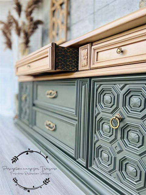 Belles and Whistles Trippy Blocks - Stencil.  A green and gold chalk painted dresser with the top center drawer halfway open.  The side of the open drawer has a stencil pattern painted on it with black chalk mineral paint.  The handles and knobs are gold.  Staged on a gray floor, in front of a gray wall.  A brown plant is in the back corner.