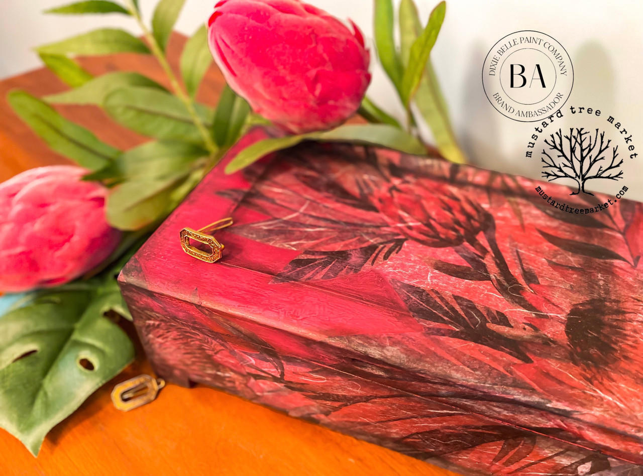 Belles and Whistles Tropical on Pink - Rice Decoupage Paper.  A small pink chalk painted box with the Tropical on Pink Rice Decoupage Paper applied the top and sides.  Sitting on a yellow table with pink flowers and greenery around it.