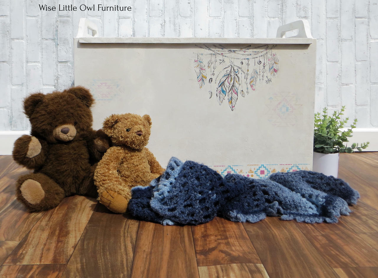 Belles and Whistles Western Boho - Silkscreen Stencil provides an extra decorative touch to any project!  A white chalk painted toy chest with the Western Boho Silkscreen Stencil applied to the front in various colors.  The toy chest sits on a brown wooden floor, in front of a white brick wall.  Two brown plush bears and a blue knitted blanket sit on the floor in front of the toy box, and a green plant sits inside of a white pot to the right of the toy chest.