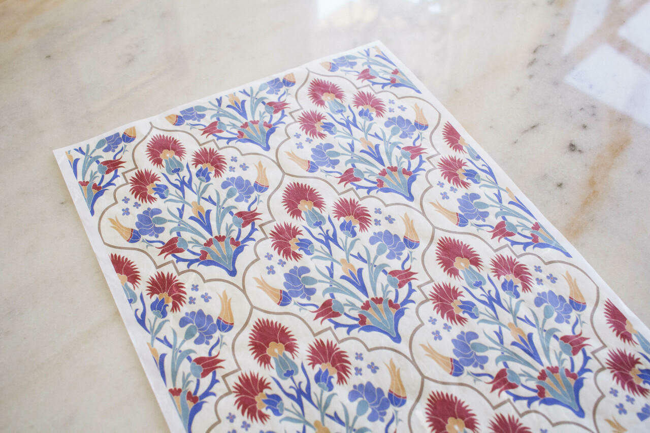 Belles and Whistles Whimsical Mediterranean - Rice Decoupage Paper is a simple way to visually enhance any surface of your project!  A sheet of the Whimsical Mediterranean Rice Decoupage Paper laid out on a white marble table.