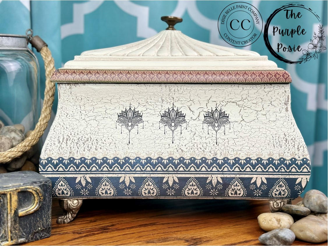 White painted jewelry box with silver feet. Crackle has been used with the paint to create a chippy, weathered look. The Bohemian Dream Transfer has been applied to the rim of the lid, the front, and on the bottom of the box.
