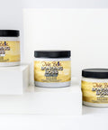 Three jars of Dixie Belle Bonding Boss, a primer, are displayed on white geometric platforms against a plain white background. The jars are 16 oz. and feature yellow and white labels with black lids.