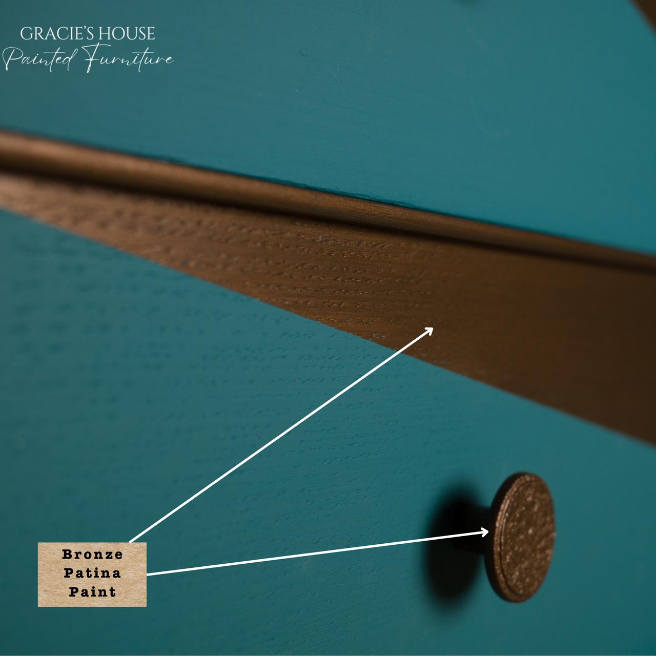 Dixie Belle Bronze Patina Paint. Close-up of a drawer featuring teal paint with a bronze patina finish. A round, textured bronze knob is visible. There's a label pointing to the painted surface, indicating "Bronze Patina Paint." The top left corner says "Gracie's House Painted Furniture.