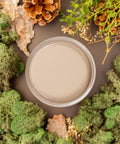 Overhead shot of Cobblestone paint jar. Staged with moss, pinecones, and mushrooms around it.