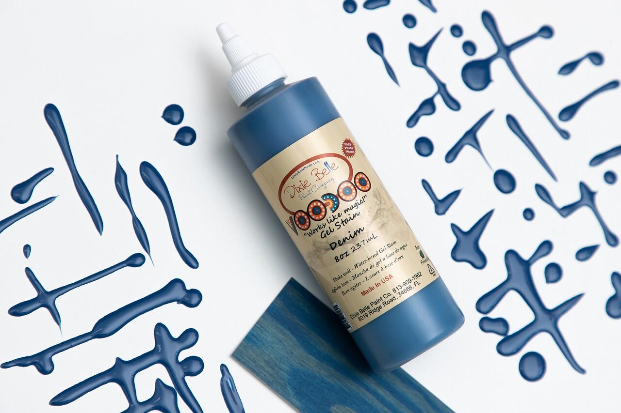 Image of Denim Voodoo Gel Stain bottle, next to it's respective stain sample card, along with lines of the stain on a white background.