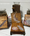 Wooden decor pieces featuring floral and feather designs, from the Desert Moon Transfer, are displayed on a white surface. Two wooden holders with glass candle cups are in the background. The text "REHAB 2 FAB DESIGNS" is visible in the top left corner.