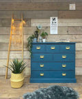 Dixie Belle Paint Antebellum Blue Chalk Mineral Paint is the perfect paint for any DIY project! Antebellum Blue Chalk Mineral Paint on dresser with gold hardware. Staged with books, reading glasses, plants and ladder light.