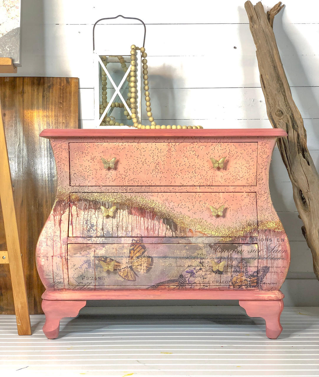 Dixie Belle Paint Apricot Chalk Mineral Paint is the perfect paint for any DIY project!
A french dresser using Apricot Chalk Mineral Paint with a dripping paint effect on half the piece. Staged around piece is a wood plank and driftwood.