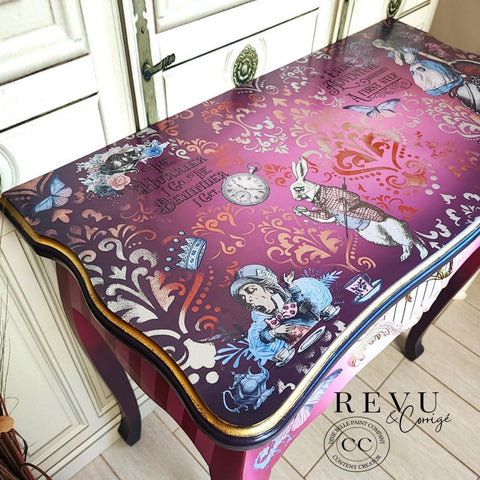 Dixie Belle Paint Aubergine Chalk Mineral Paint is the perfect paint for any DIY project! This table is painted with various Dixie Bellle Chalk Mineral paint colors incliding Aubergine Chalk Mineral Paint. The sides are striped and the top is a mix if pink fading to purple. It is accented with gold hardware and our Alice transfer.