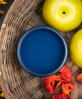 Dixie Belle Paint Bunker Hill Blue Chalk Mineral Paint is the perfect paint for any DIY project!
The opened container of Bunker Hill Blue Chalk Mineral Paint staged with yellow apples and pink-orange flower petals inside a woven basket and yellow flowers on a branch outside the basket.